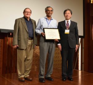 Dr. Ravi Nair (center), a researcher at the IBM Thomas J. Watson Research Center, formally receives the 2018 B. Ramakrishna Rau Award in October during the 51st Annual IEEE/ACM International Symposium on Microarchitecture (MICRO51), which was held in Fukuoka City, Japan, and saw record attendance this year. Joining him is Award Chair Kemal Ebcioglu (left, also a 2013 Rau Award winner) and IEEE Computer Society President Hironori Kasahara. The Rau Award honors significant contributions in the field of computer microarchitecture and compiler code generation.
