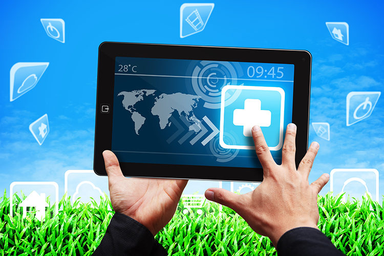 Hands holding a tablet, with grass